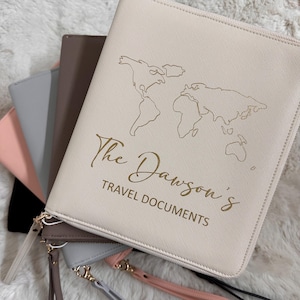 May include: A cream-coloured travel document holder with a gold outline of a world map and the text "The Dawson's Travel Documents".