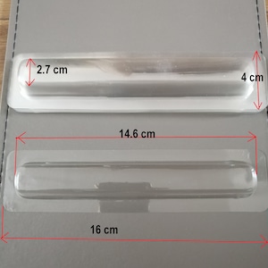 Peut inclure: Deux plateaux en plastique transparent avec des bords surélevés, conçus pour contenir des objets longs et fins. Le plus grand plateau mesure 16 cm sur 4 cm, tandis que le plus petit plateau mesure 14,6 cm sur 2,7 cm.
