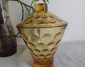 May include: A vintage amber glass candy jar with a lid. The jar has a textured surface with small circles.