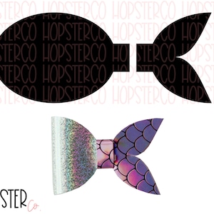 Pode incluir: Um laço de cabelo de cauda de sereia preto e roxo com glitter iridescente. O laço é feito de tecido e tem a forma de uma cauda de sereia com escamas.