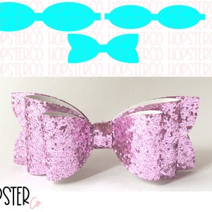 Może przedstawiać: Różowa błyszcząca kokardka z falbanką. Kokardka jest wykonana z tkaniny i ma białe centrum. Kokardka jest zawiązana białą wstążką.