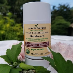 Puede incluir: Barra de desodorante blanca con una etiqueta marrón que dice "Aurelia Natural Let's Grow Organic Naturally Derived Long Lasting Deodorant Aluminum & Parabens Free No Artificial Fragrance Cedarwood + Rose Mary USDA Organic Vegan Friendly Net Wt. 3.25 Oz (90g)"