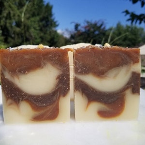 May include: Two bars of handmade soap with a brown and white swirl pattern. The soap is made with natural ingredients and is perfect for sensitive skin.