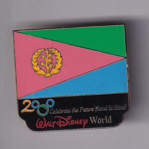 May include: A black and red enamel pin featuring the flag of Eritrea with the text "2000 Celebrate the Future Hand in Hand WALT DISNEY World" underneath.