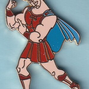 May include: A gold-colored pin of a cartoon character wearing a red and blue costume. The character is flexing his bicep and has a determined expression on his face.
