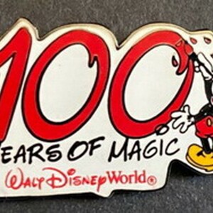 May include: A red and white pin with the number 100 in red, the words "Years of Magic" and "Walt Disney World" in black. Mickey Mouse is depicted in black and red, painting the number 0.