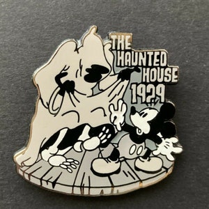 May include: Black and white enamel pin featuring Mickey Mouse and a ghost. The pin says "The Haunted House 1929".