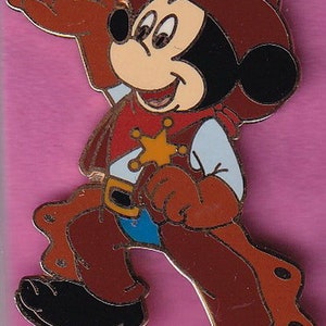 Könnte beinhalten: Eine Zeichentrickfigur von Mickey Mouse, die als Cowboy verkleidet ist. Er trägt einen braunen Hut, ein rotes Hemd mit einem gelben Stern, eine braune Hose und braune Stiefel. Er lächelt und hält ein Lasso.