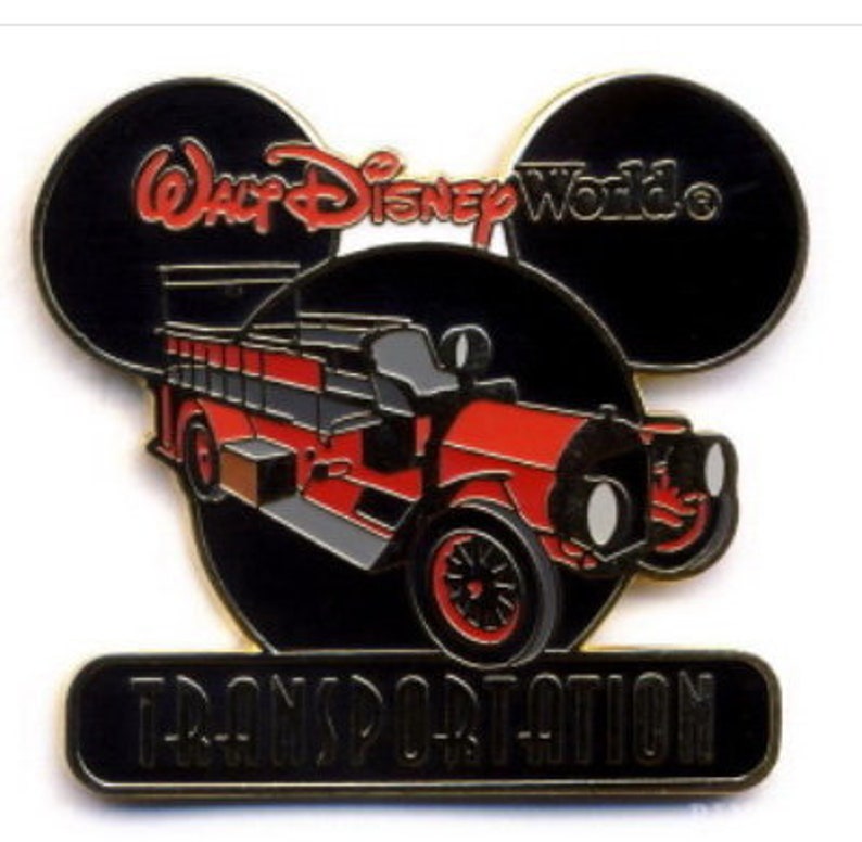 May include: A red vintage fire truck with black wheels and a black background. The truck is in front of a black Mickey Mouse head with the text "Walt Disney World" in red and white. The text "Transportation" is below the truck in black.