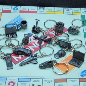 Llaveros metálicos reciclados de Monopoly Edición Aquí y Ahora, TV de pantalla plana, gorra Segway Altoids, transbordador espacial, perro en bolso