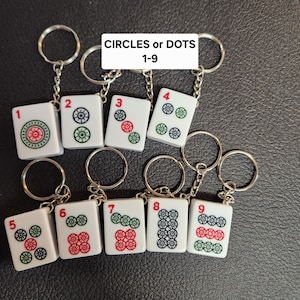 Puede incluir: Nueve llaveros blancos con c&iacute;rculos o puntos negros, verdes y rojos. Cada llavero tiene un n&uacute;mero del 1 al 9. Los llaveros est&aacute;n etiquetados como "CIRCLES or DOTS 1-9".
