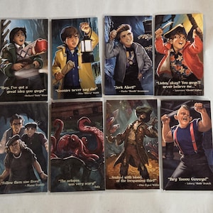May include: Eight rectangular cards with illustrations of characters and quotes from the film "The Goonies." Each card shows a different character with a quote, including "Jerk Alert!" and "The octopus was very scary!"