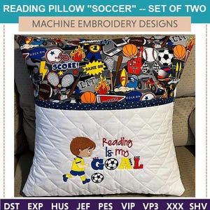 Könnte beinhalten: Weißes Lesekissen mit einer Tasche und einem bunten Fußball-Stoff auf der Rückseite. Die Vorderseite des Kissens ist mit einem gestickten Design eines Fußball spielenden Jungen mit dem Text "Reading is my GOAL" verziert.