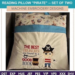 May include: A white reading pillow with a blue pocket and a pirate-themed embroidery design. The embroidery features a pirate holding a hook, a treasure chest, and the text "The best treasures are found in a good book".