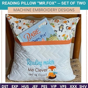 May include: A white reading pillow with a pocket for a book. The pillow has a fox design and the text "Reading makes Me Clever as a fox!" embroidered on it. The pillow is on a wooden chair with a book in the pocket.