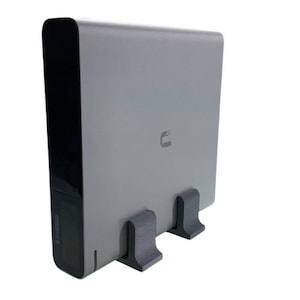 May include: A gray external hard drive with a black front panel and two black plastic feet. The hard drive has a small logo on the front.