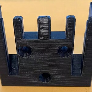 May include: Black plastic 3D printed wall mount with three slots and two holes.