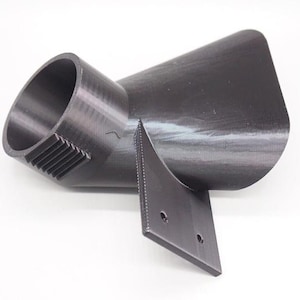 May include: A black plastic 3D printed adapter with a round opening and a flat base. The adapter has a cone shape and is designed to connect two different sized pipes.