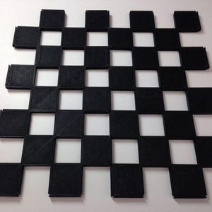 May include: A black and white checkerboard pattern made of 36 small squares. The squares are arranged in a grid pattern, with alternating black and white squares.