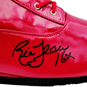 May include: A red patent leather boxing shoe with black laces and a black signature that reads "Ali Jean 16+ "