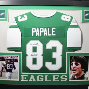 May include: Framed green and white Philadelphia Eagles jersey with the number 83 and the name "PAPALE" on the back. The jersey is signed by the player. The frame includes a photo of the player in action and a close-up of his face.