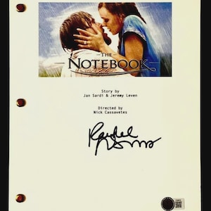 Puede incluir: Un guion de película color crema para "The Notebook" con una imagen en color de los actores de la película besándose. El título está impreso en letras grandes. El guion está firmado por Rachel McAdams.