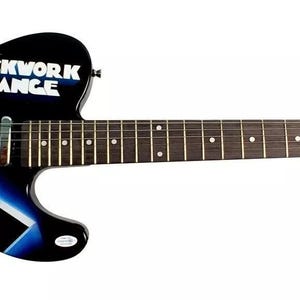 Op de afbeelding: Een zwarte elektrische gitaar met een "Clockwork Orange" ontwerp. De body heeft een filmposter graphic met de titel van de film in het wit. De kop is voorzien van "Special Edition".