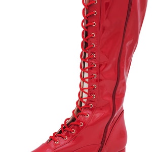 May include: Red leather wrestling boots with a lace-up front and a zipper on the side.