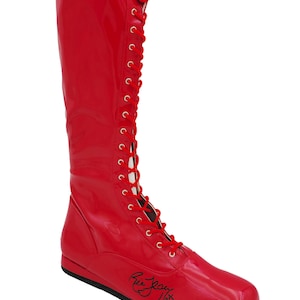 May include: Red leather wrestling boot with a black lace-up closure and a black signature on the sole. "Ric Flair 16x"