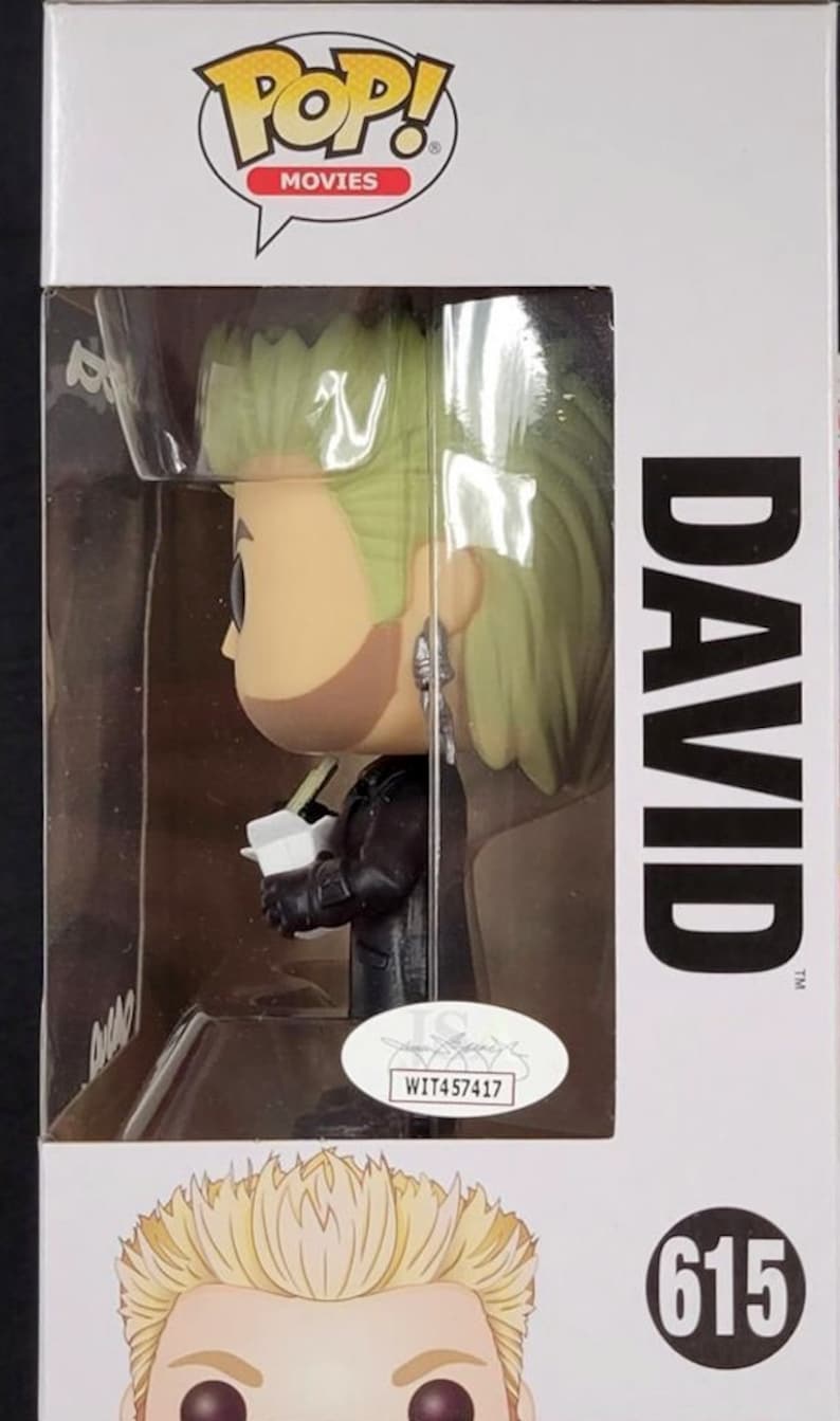 May include: A Funko Pop! Movies figure of David from the film "The Lost Boys." The figure has a stylized design with green hair, a black jacket, and is holding a white object. The box features the Pop! Movies logo and the number 615.