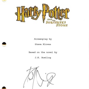Puede incluir: Una página blanca con el título "Harry Potter and the Sorcerer's Stone" en letras doradas. El guion es de Steve Kloves, basado en la novela de J.K. Rowling. La página está firmada y tiene tres agujeros perforados.
