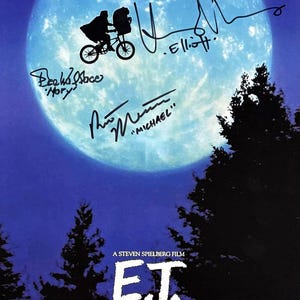 May include: E.T. movie poster featuring a silhouette of a child and alien on a bicycle in front of a large moon. The poster includes the film's title, credits, and signatures.