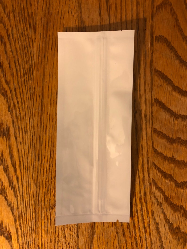 May include: A white stand-up pouch with a zipper closure. The pouch is made of a flexible, opaque material.
