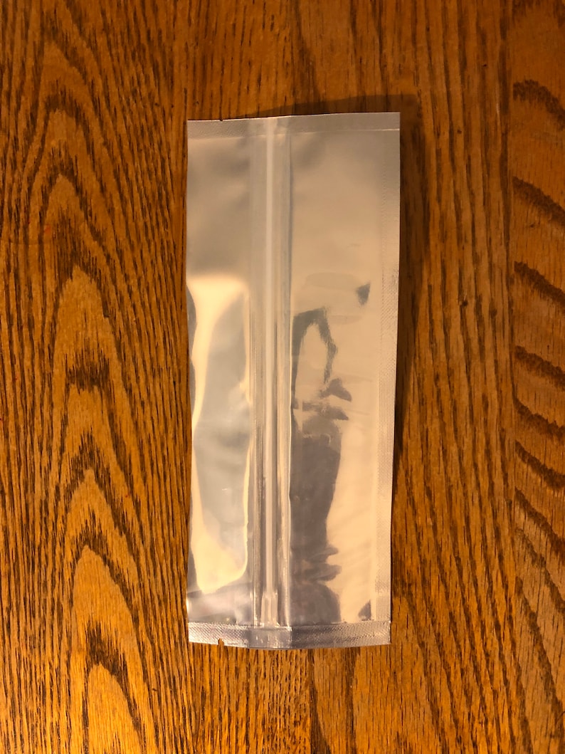 May include: A clear plastic stand-up pouch with a zipper closure. The pouch is made of a shiny, metallic material.