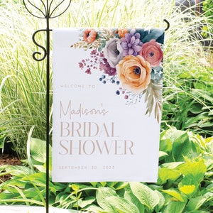 May include: A white garden flag with a floral design and the text "Welcome to Madison's Bridal Shower September 30, 2023".