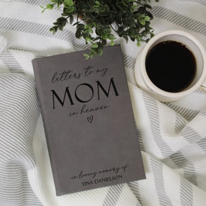 May include: Grey journal with the text "letters to my MOM in heaven" and a small heart symbol. The journal also has the text "in loving memory of TINA DANIELSON".
