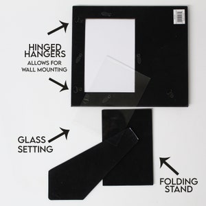 May include: Black picture frame with a glass setting, hinged hangers for wall mounting, and a folding stand.