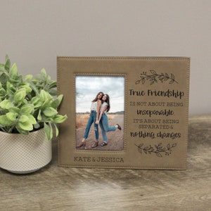 May include: A brown faux leather picture frame with a quote about true friendship. The quote reads "True Friendship is not about being inseparable. It's about being separated & nothing changes". The frame has a photo of two women in it and the names "Kate & Jessica" are printed below the photo.