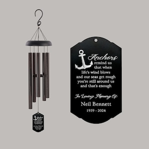 May include: Black wind chime with a metal plaque that reads "Anchors remind us that when life's wind blows and our seas get rough you're still around us and that's enough. In Loving Memory Of Neil Bennett 1959-2024"