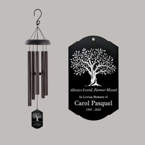 May include: Black metal wind chime with a tree design and the text "Always Loved, Forever Missed In Loving Memory of Carol Pasquel 1947 - 2023".