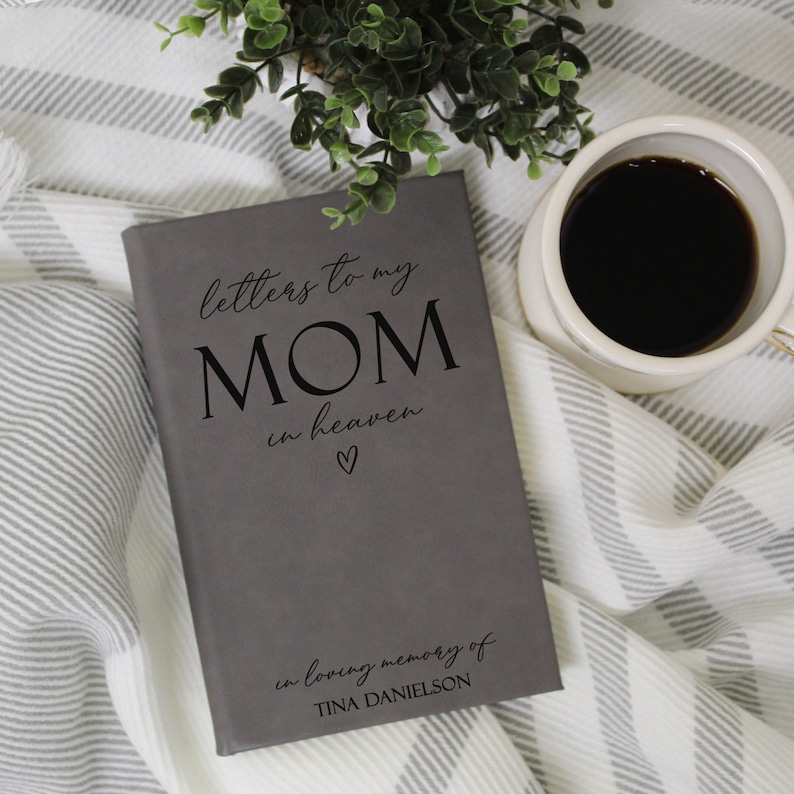 May include: Grey journal with the text "letters to my MOM in heaven" and a small heart symbol. The journal also has the text "in loving memory of TINA DANIELSON".