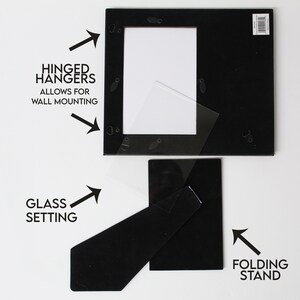 May include: Black picture frame with a glass setting, hinged hangers for wall mounting, and a folding stand.