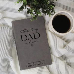 Może przedstawiać: Szary dziennik z tekstem "letters to my DAD in heaven" i małym symbolem serca. Pod tekstem widnieje napis "in loving memory of ROBERT M. HERRINGTON".