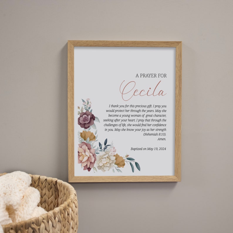 May include: A framed print with a floral design and a prayer for Cecila. The text reads "A Prayer for Cecila. I thank you for this precious gift. I pray you would protect her through the years. May she become a young woman of great character, seeking after your heart. I pray that through the challenges of life, she would find her confidence in you. May she know your joy as her strength (Nehemiah 8:10). Amen. Baptized on May 19, 2024."