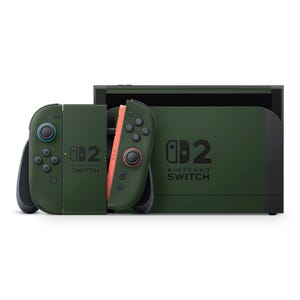 May include: A green Nintendo Switch console with matching Joy-Con controllers. The controllers have blue and orange accents. The console and controllers feature the Nintendo Switch logo and the number "2".