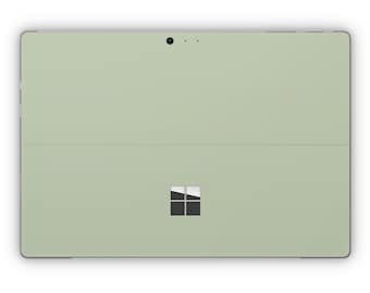 May include: A light green tablet computer with a black Microsoft logo on the back.
