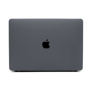 May include: A closed grey laptop computer with an Apple logo on the lid.