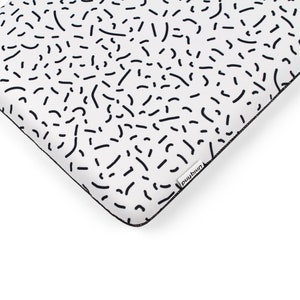 Puede incluir: Funda para port&aacute;til blanca con un patr&oacute;n geom&eacute;trico en blanco y negro. La funda tiene una cremallera negra y una peque&ntilde;a etiqueta negra con la palabra "mind" impresa en ella.