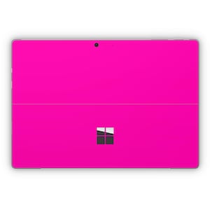 Puede incluir: Una tableta Microsoft Surface de color rosa brillante con un logotipo de Windows negro en la parte posterior.