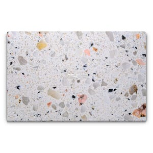 May include: A close-up of a white terrazzo surface with small, colourful chips of stone. The surface is smooth and has a subtle sheen.